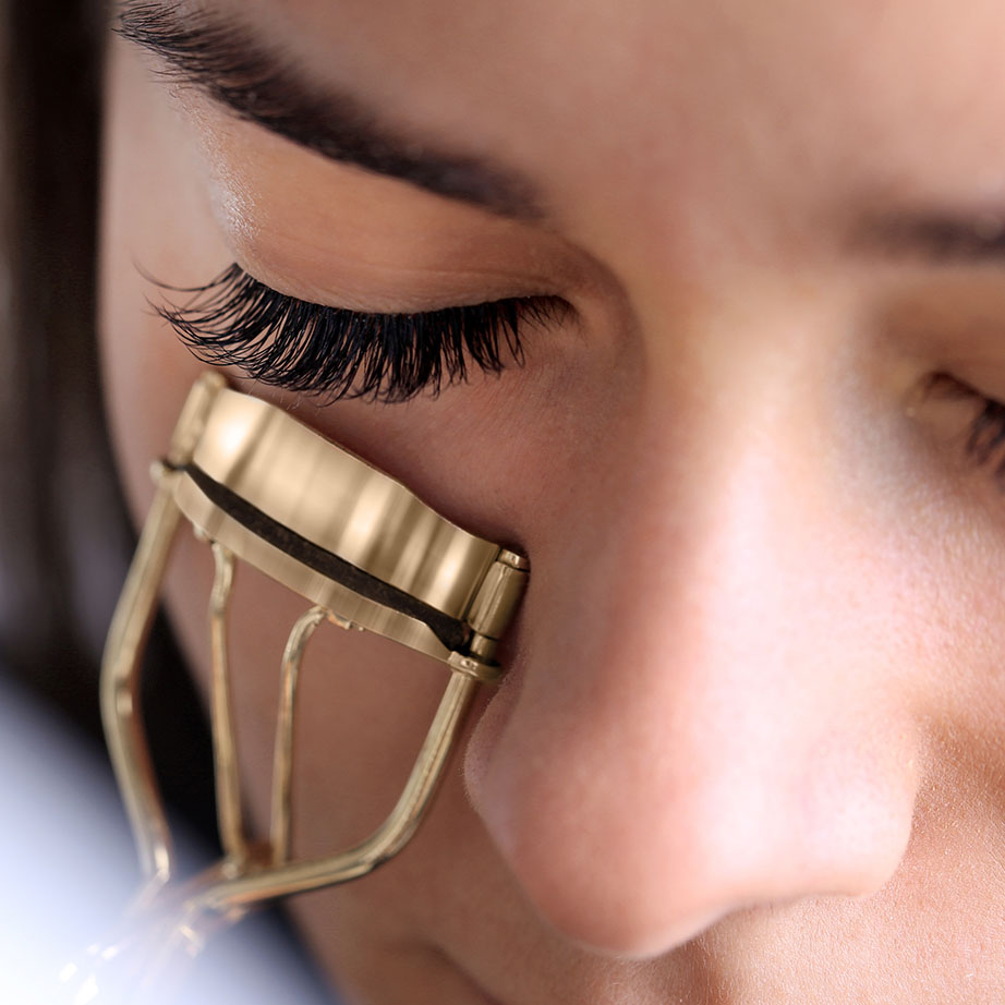 woman using eyelash curler