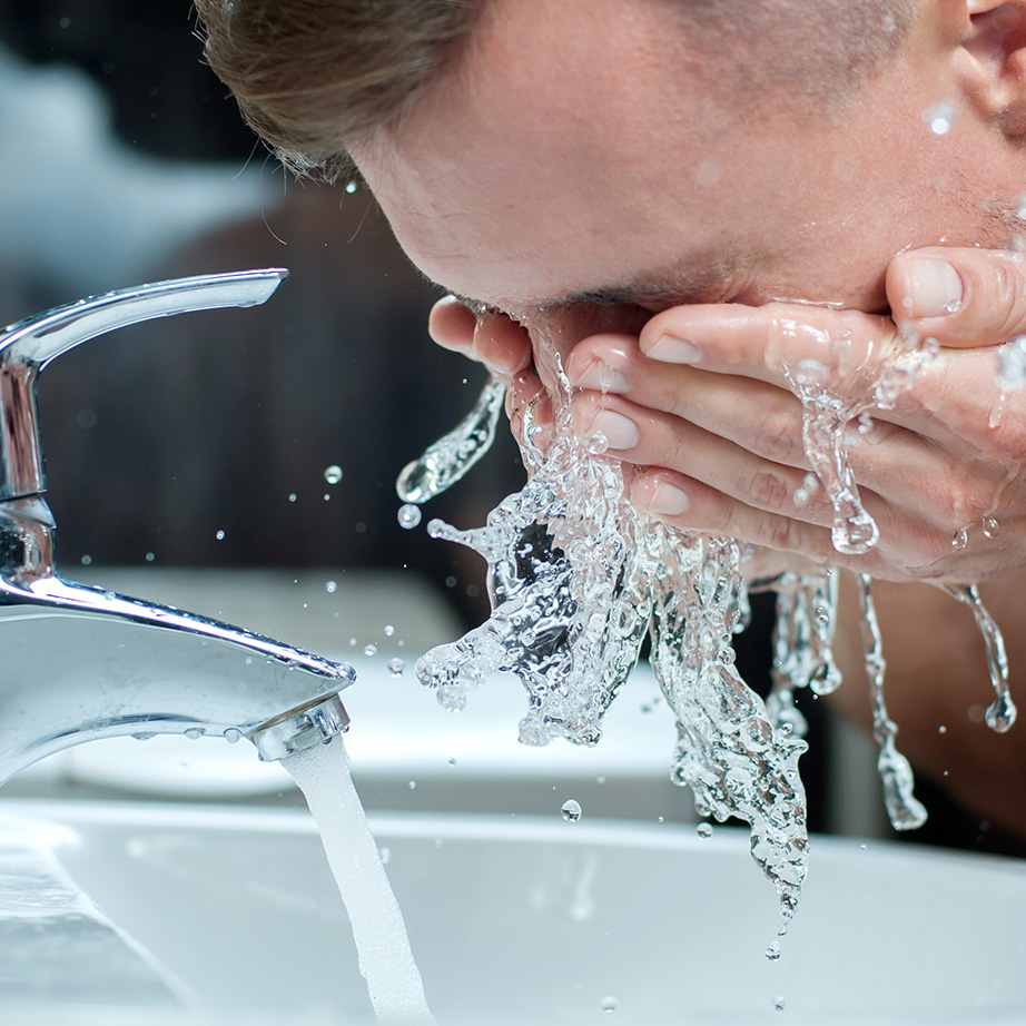 man washing face