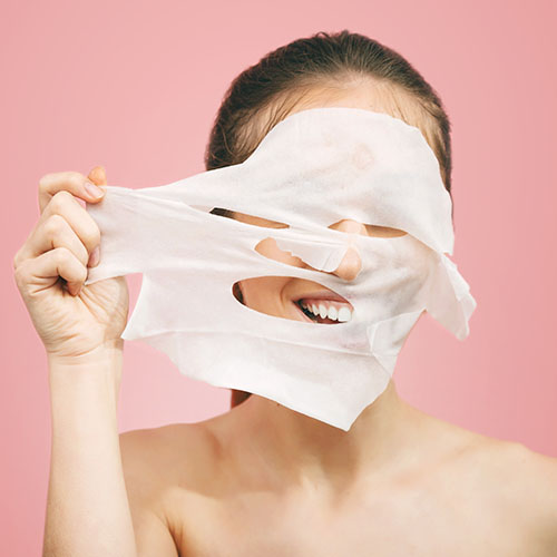 woman removing sheet mask