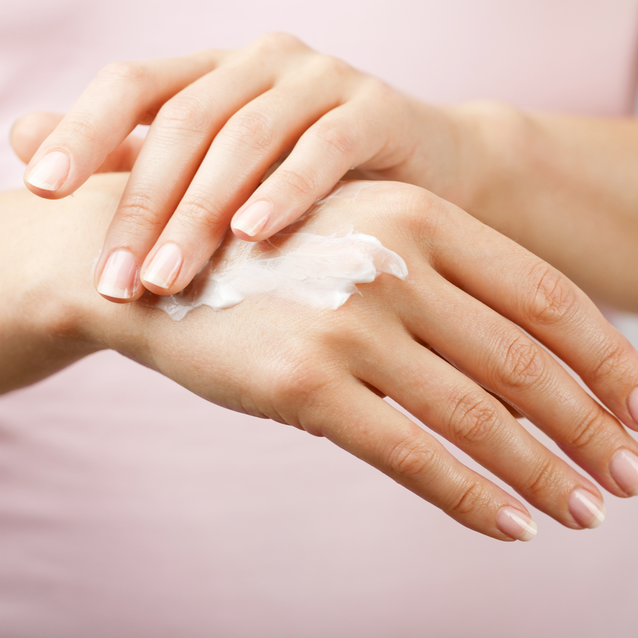 woman applying lotion to hands